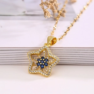 Gold-plated star pendant necklace with sparkling blue and clear zircon stones on a book