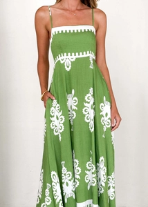 Detailed view of green floral summer dress showing side pocket and linen fabric texture