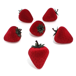 Set of six red flocked strawberry-shaped mini jewelry boxes on a white background
