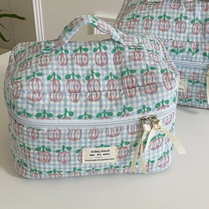 Close-up of blue plaid quilted cotton makeup bag with tulip pattern and ribbon detail