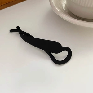 Vue détaillée d'une pince à cheveux banane noire mate en forme de 8 sur fond blanc