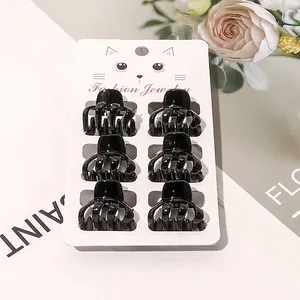 Set of 6 mini glossy black plastic hair claws on a stylish cat-themed retail card