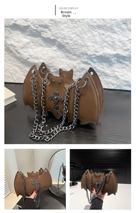 Detail view of gothic bat-shaped chain bag in brown with cross metal hardware and silver strap
