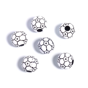 Macro detail of acrylic soccer ball beads with black and white star patterns for DIY jewelry