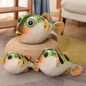Trois peluches de poisson-globe mignonnes de différentes tailles sur un tabouret tressé