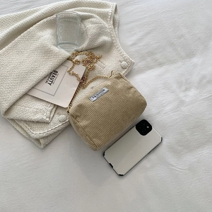 Detailed view of beige corduroy shoulder bag texture with fashion instinct label