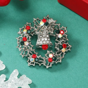 Sparkling Christmas wreath brooch with bells and colorful rhinestones on festive background