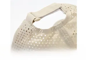 Close-up of adjustable velcro strap and laser-cut vents on the beige baseball cap