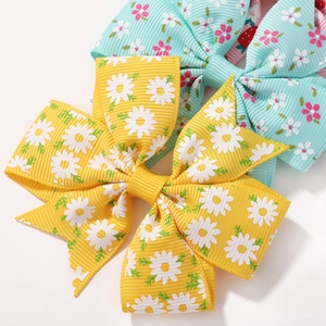 Floral daisy print hair bows for children featuring yellow and light blue ribbon styles