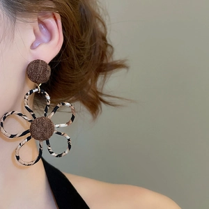 Détail macro de boucles d'oreilles fleurs en tissu léopard au style bohème vintage