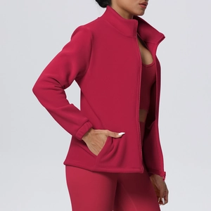 Detail of high neck zip-up yoga jacket in dark red fleece with side pocket design