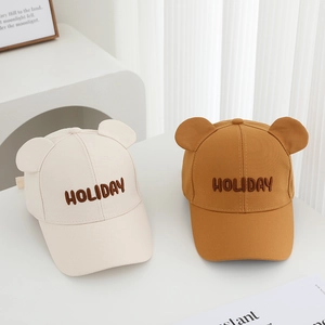 Detail of children baseball caps with holiday embroidery and cute teddy bear ears decor