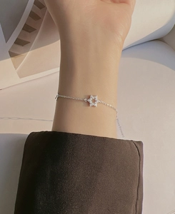 Detailed view of a sparkling star pendant bracelet on a woman wrist with micro pavé stones