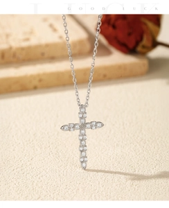 Macro shot of silver cross pendant with VVS1 moissanite and dry rose background