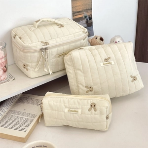 Three-piece beige quilted storage bag set featuring cute rabbit embroidery in life scene