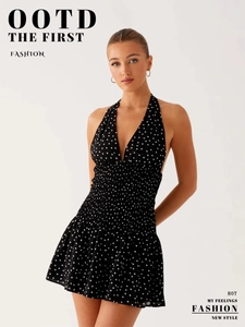 Detailed view of the smocked waist and polka dot pattern on a halter neck dress