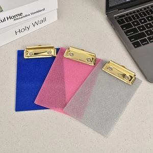 Detailed view of blue pink and silver glitter acrylic clipboards with gold metal clips
