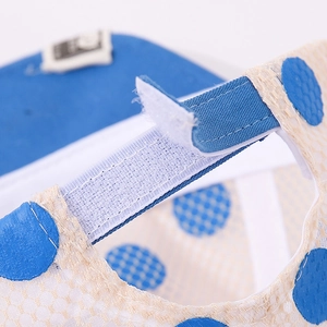 Détail de la sangle Velcro bleue et du tissu en maille respirant du chapeau bébé