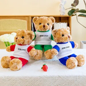 Tres lindos ositos de peluche con uniformes escolares de colores sobre una mesa.