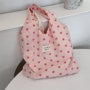 Close-up of pink heart pattern canvas tote bag with decorative sozakka beauté label