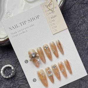 Handmade brown amber gradient press-on nails with bow, pearls, and rhinestone accents