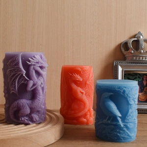 Detailed relief dragon and bird patterns on colorful cylindrical handmade candles