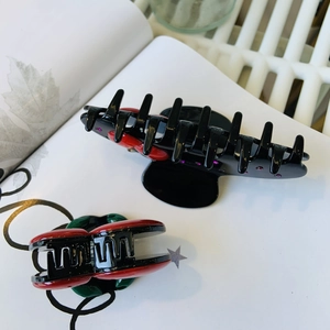Retro black acetate hair claw clips with cherry motifs and purple crystal accents
