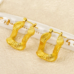 Detail of gold-plated rectangular hoop earrings with vertical wavy textured surface