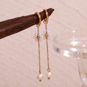 Detailed close-up of 18K gold plated hoop earrings with pearl flower and long chain tassels