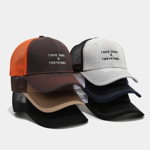 Detail of embroidered slogan on breathable mesh trucker hat with contrast color stitching