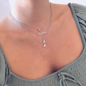 925 silver layered necklace with L, mama, pineapple, and cactus charms on model