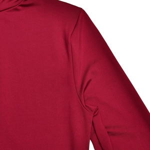 Détail de la robe rouge à manches longues montrant l'épaule et le tissu extensible