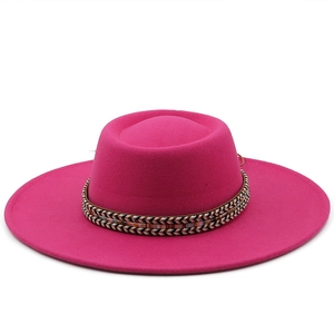 Detail of rose red wool felt flat top hat featuring a colorful ethnic woven band decoration