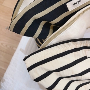 Close-up of striped cotton canvas makeup bags with zipper closure and simple label