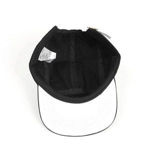 Vista interna del cappellino nero che mostra la fascia bianca e l'etichetta taglia