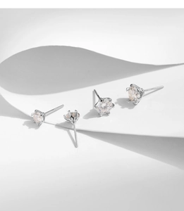 Macro detail of 1 carat moissanite stud earrings with classic four-prong silver setting