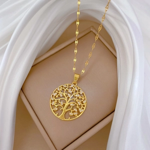 Macro shot of gold tree of life necklace pendant with zircon stones on beige jewelry pad