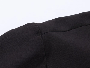 Close-up of high-quality stitching on black woven fabric of a short sleeve polo shirt