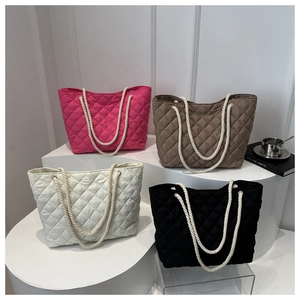 Détail de sacs cabas matelassés en nylon en quatre couleurs avec anses en corde épaisse