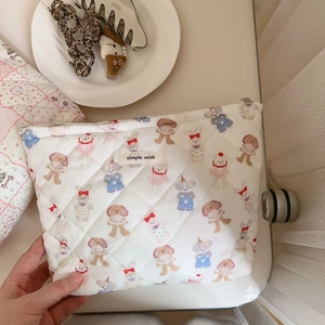 Detail of white quilted cosmetic bag featuring cute cartoon animals and simple wish label