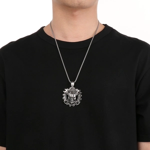 Close-up of a punk style skull pendant with crossed wrenches on a black t-shirt