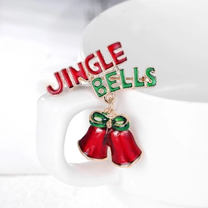 Festive Jingle Bells brooch with red enamel bells and green bow on a white cup
