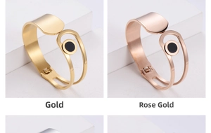 Detail of minimalist gold and rose gold stainless steel bangles with black inlay