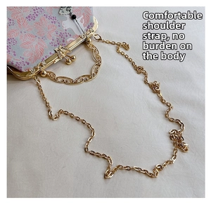 Detail of floral shell bag featuring gold butterfly clasp and wavy metal handle