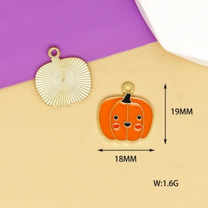 Detailed view of orange enamel pumpkin pendant with front smile and back gold texture