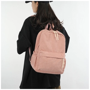 Close-up of soft pink corduroy backpack featuring wide ribbed texture and sturdy zippers