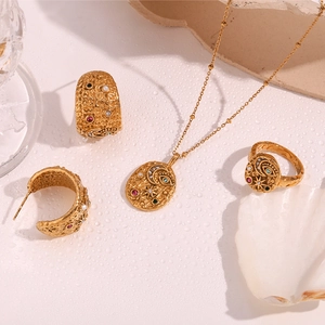Flat lay of vintage gold jewelry set with colorful gemstones and mystic moon symbols