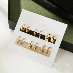 Detailed close-up of six-pair gold earring set with zircon and textured metal designs