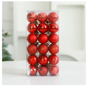 Detail of red Christmas tree ornaments set with matte, glitter and glossy finishes