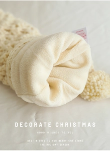 Detail of soft plush lining and chunky knit texture of a beige Christmas stocking